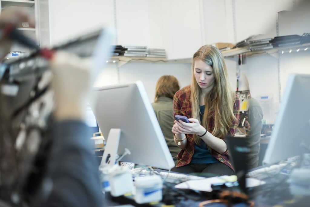 Absolute ICT staff using a smart phone. People working on computer repairs.