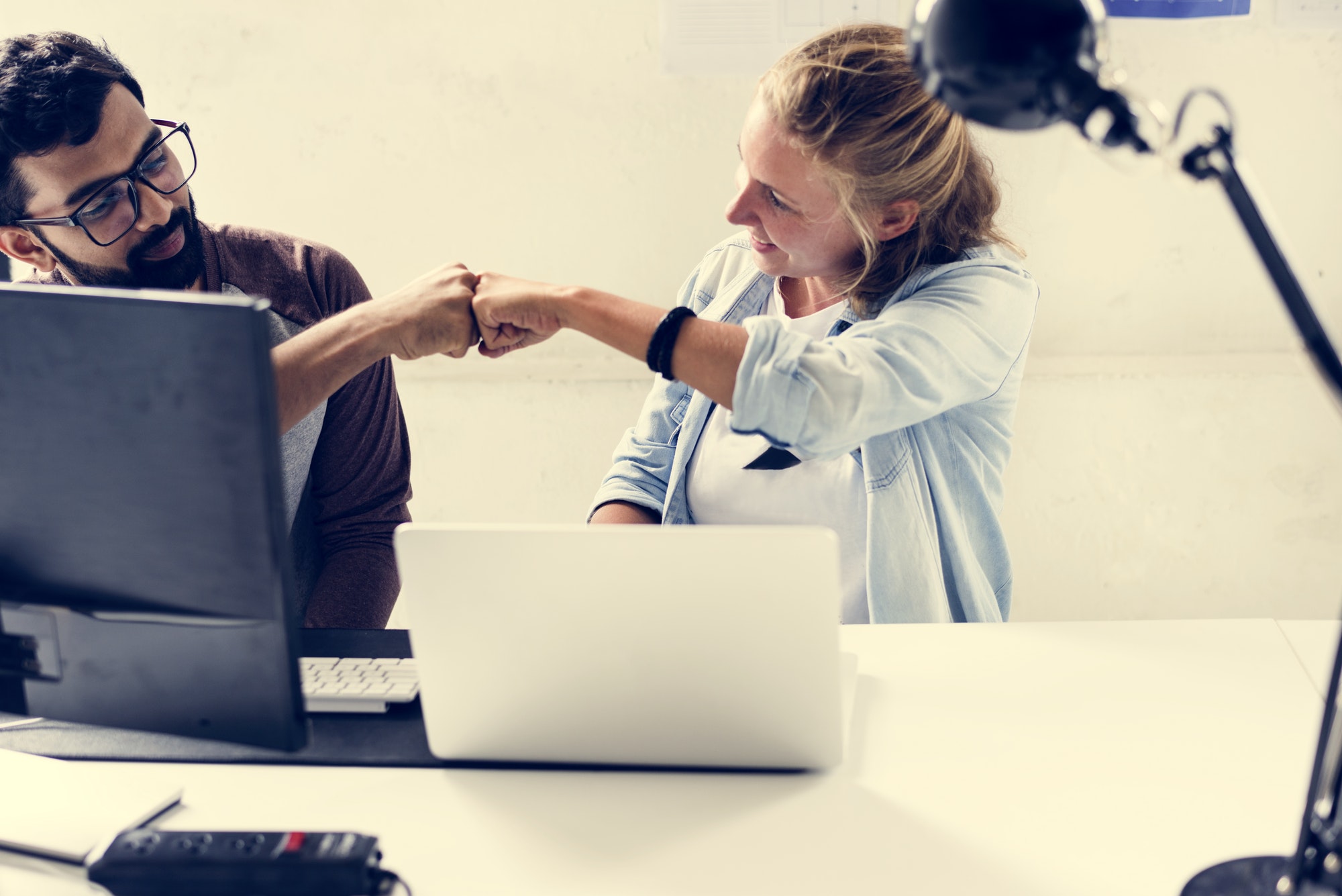 Computer technicians friends hit fists together