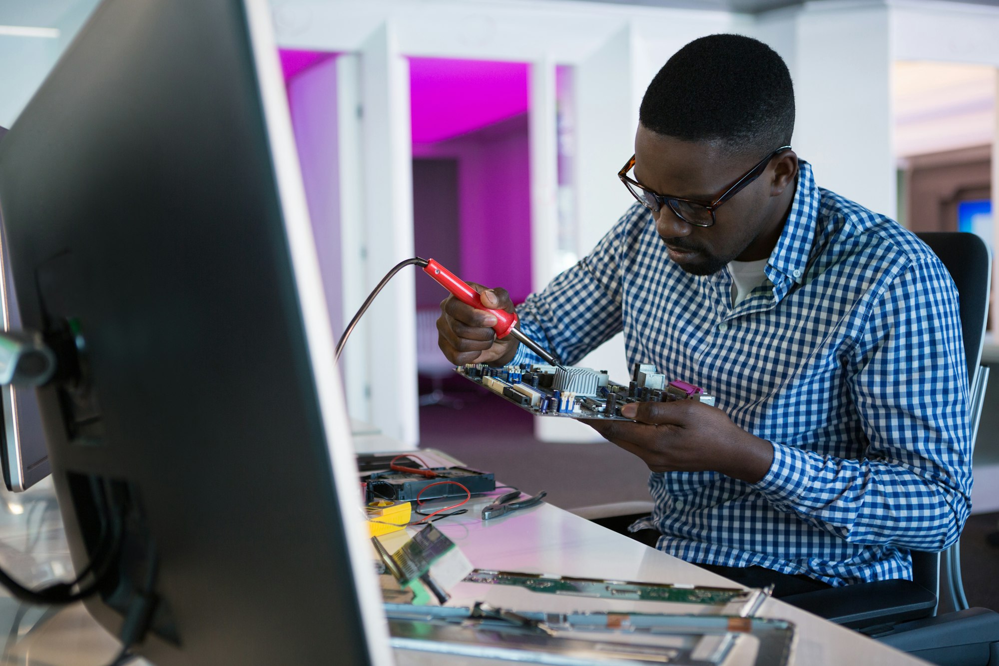 Computer engineer repairing motherboard at desk